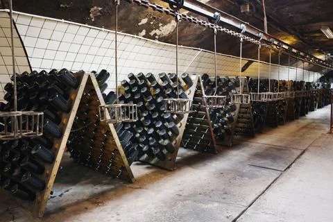 Unique wine cellar with rows of resting bottles in a vintage setting Stock Photos