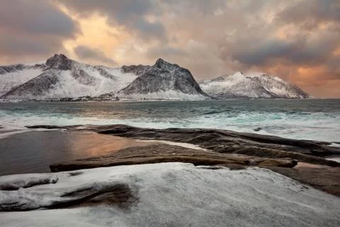 Unique winter sea landscape with dramatic sky and mountains Stock Photos