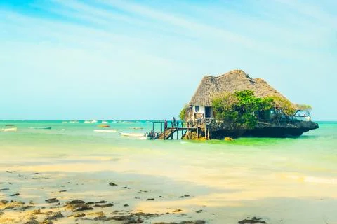 Unique wooden restaurant structure built on coral rock outcrop in turquoise.. 库存照片