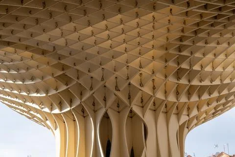 Unique wooden structure with geometric patterns and curved beams. Stock Photos