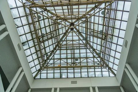 Unique yellow geometric ceiling design in a rectangular white room with large 스톡 사진