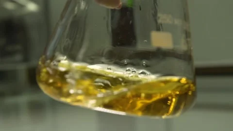 Unique yellow liquid being mixed inside a medical flask. Stock Footage 132963164