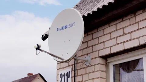 Unisat satellite dish receiver close view on brick building in Daugavpils Vídeo Stock 343733789