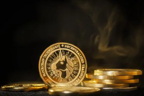 Uniswap cryptocurrency coin stack on dark background with smoke Foto stock