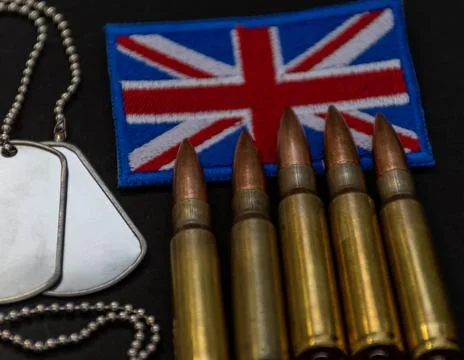 United Kingdom flag patch with bullets and dog tags close up on black surface Stock Photos