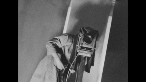 United States 1930s: A large format camera. Man covers his head with a cloth to Stock Footage 324817956