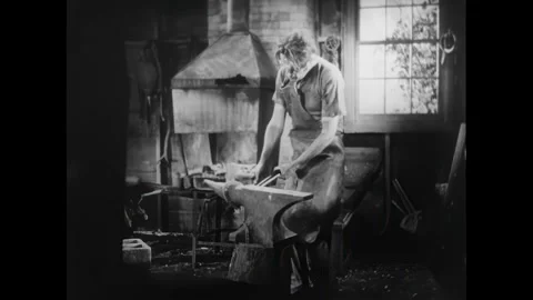 UNITED STATES - 1936 - A blacksmith makes a horseshoe and a coachman stops to Stock Footage 340665055