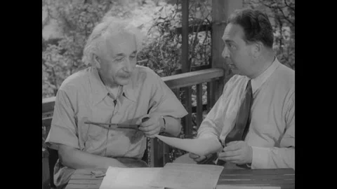 United States 1940s: Albert Einstein sits outdoors with a colleague, reviewing Stock Footage 325219452