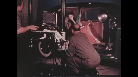 United States 1940s: Man frames a photograph of a woman sitting in the backseat Stock Footage 346423347