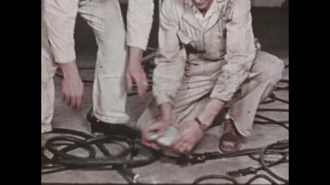 United States 1940s: Men plug in and unroll power cables. Man adjusts a camera Stock Footage 346423145