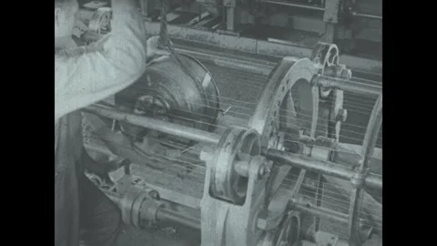 United States 1940s: A worker operates a large industrial weaving machine in an Stock Footage 340085072