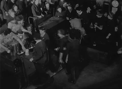 UNITED STATES - 1942: Workforce break - Capped employees sit close together Stock Footage 344508934