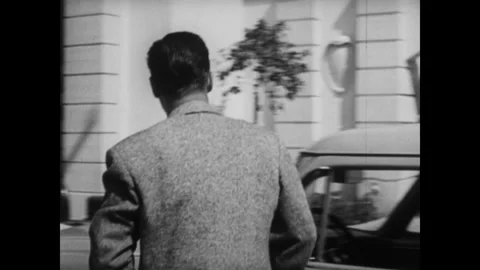 United States 1950s: Car pulls to stop, man gets out of car. Man walks down Stock Footage 320310163