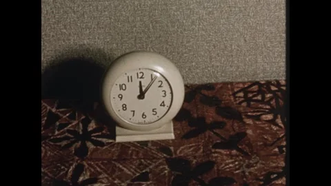 UNITED STATES 1950s: Clock on bedside table. Man lies in bed, having restless Stock Footage 332376192