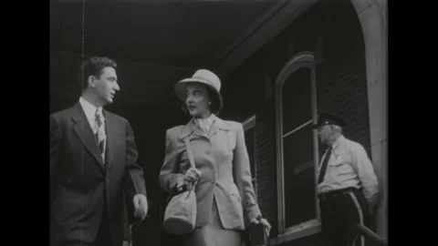 United States 1950s: Low angle, people exiting building, walking down stairs. Stock Footage 328589046