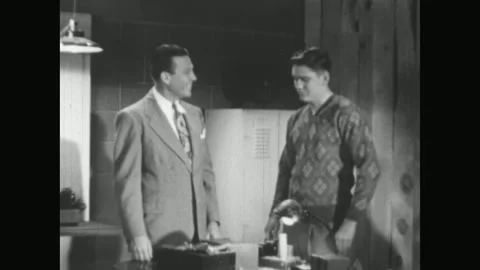 UNITED STATES 1950s: A man in a patterned shirt stands near an open door with Stock Footage 337061234