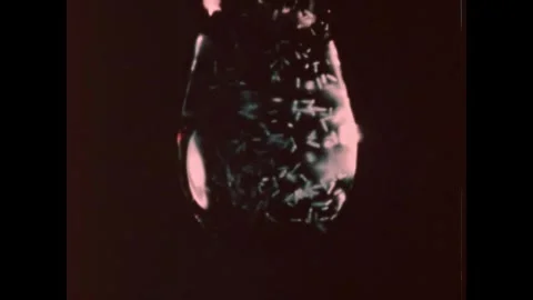 UNITED STATES 1950s: A single, large water droplet hangs suspended against a Stock Footage 336140261