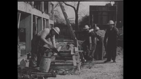 United States 1950s: Two construction workers in hard hats labor at a building Stock Footage 343402699