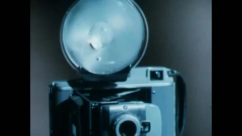 UNITED STATES - 1958 - The camera flashes as a stick presses its button to take Stock Footage 328187171