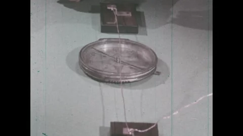 UNITED STATES 1960s: Compass between two electrified magnetic objects, needle Stock Footage 312569872