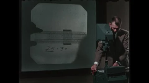 United States 1960s: Man using overhead projector, writing on slides, moving Stock Footage 322142435
