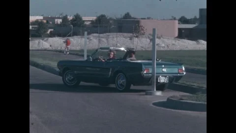 United States 1960s: Posts on the side of a road. Woman attempts to parallel Stock Footage 327567632