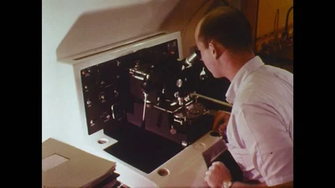 UNITED STATES: 1960s: worker looks down microscope. Research scientists  Stock Footage