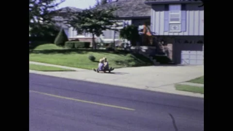 United states 1969, Kids on Skateboard Going Down Driveway of Typical 1960s.. Stock Footage 239622572