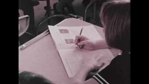 United States 1970s: Interior elementary school. Girl sits at desk, doing math Video stock 322173795