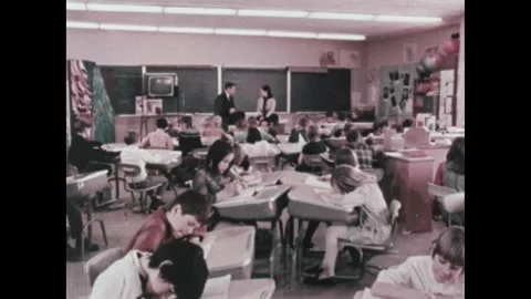 United States 1970s: Interior elementary school. Busy classroom.  Students sit Stock Footage 322173798