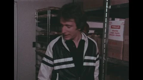 United States 1970s: Workers in a fast food restaurant storage room. A young Stock Footage 343397374
