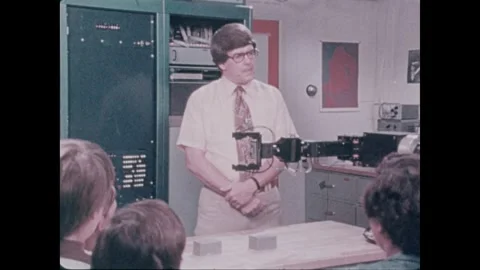 United States 1980s: Computer program on a screen. Man speaks behind a robot arm 스톡 동영상 327548767