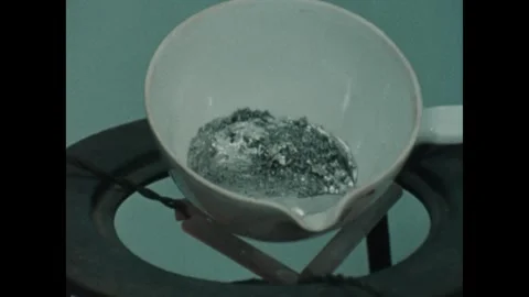 UNITED STATES 1980s: Elements inside cup melt. Compounds demonstrated with Stock Footage 310144349