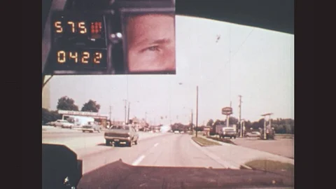 UNITED STATES: 1980s: view of man's face as he drives along busy road. Road Stock Footage