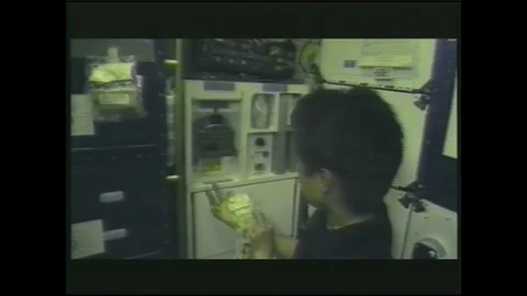 United States 1990s: Aboard a space shuttle, astronauts prepare freeze-dried Stock Footage 128213089