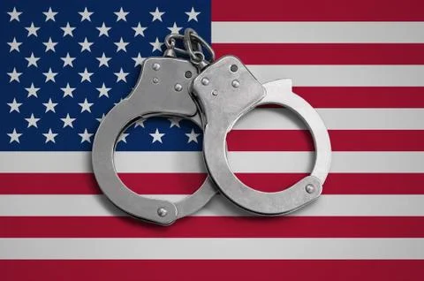 United States of America flag  and police handcuffs. The concept of observanc Stock Photos