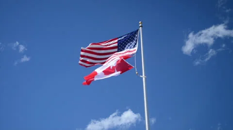 United States and Canada Flags against Blue Sky Vídeos de archivo 24907556