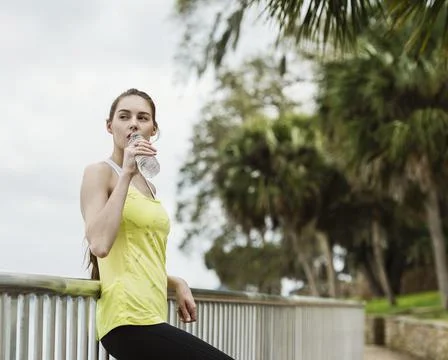 United States, Florida, Tampa, Woman in sports clothing leaning on fence and Stock Photos
