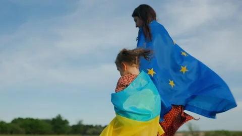Unity Across Borders Mother and Daughter Stroll Together, Flags of Ukraine and Stock Footage 274703166