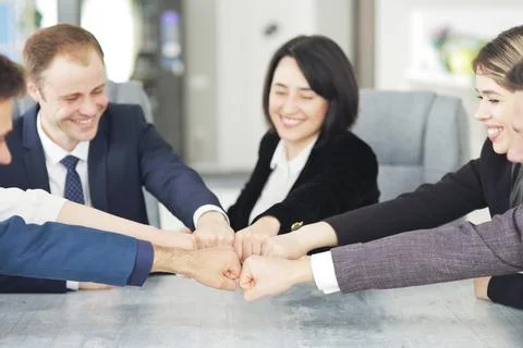 Unity and teamwork concept of young business people folding their hands together Stock Photos