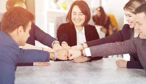 Unity and teamwork concept of young business people folding their hands toget Stock Photos