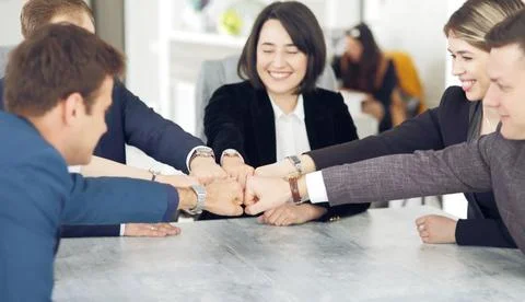 Unity and teamwork concept of young business people folding their hands toget Stock Photos