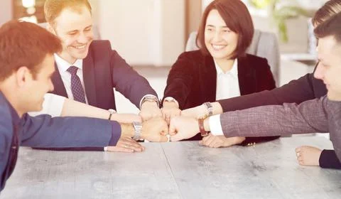 Unity and teamwork concept of young business people folding their hands toget Stock Photos