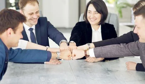Unity and teamwork concept of young business people folding their hands toget Stock Photos