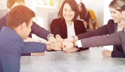Unity and teamwork concept of young business people folding their hands toget Stock Photos