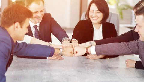 Unity and teamwork concept of young business people folding their hands toget Stock Photos