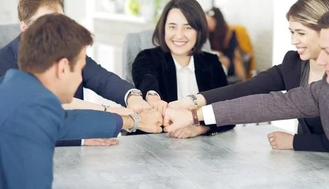 Unity and teamwork concept of young business people folding their hands toget Stock Photos
