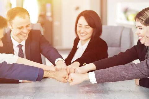 Unity and teamwork concept of young business people folding their hands together Stock Photos