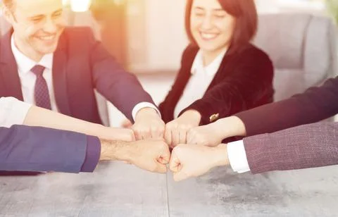Unity and teamwork concept of young business people folding their hands together Stock Photos