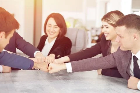 Unity and teamwork concept of young business people folding their hands together Stock Photos